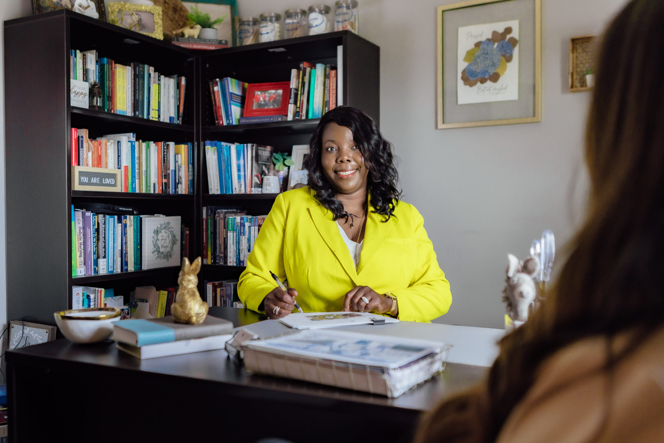 woman sitting at desk with person