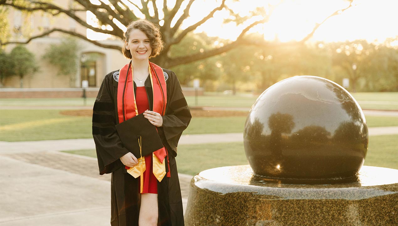 globe statue with graduate